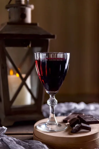 Sklo s červeným vínem. Blízké zlomený čokoládový. Lucerna s candl — Stock fotografie