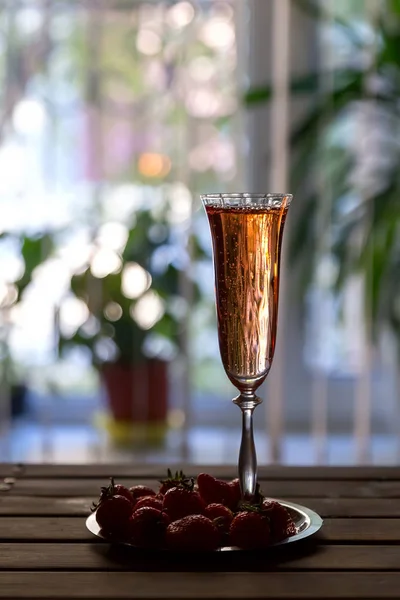 แก้วแชมเปญสีชมพูและสตรอเบอร์รี่บนโต๊ะไม้ — ภาพถ่ายสต็อก