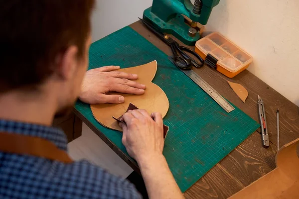 主人在车间里用真皮干活 工匠为未来的产品用砂纸剥皮 皮革工匠的工作过程 — 图库照片