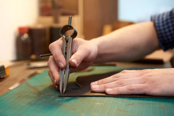 クラフトツールを使用して天然皮革に縫い目の幅を測定するマスターの閉鎖 天然皮革で縫い代の幅を測定する職人の男性の手 革職人の作業工程 — ストック写真