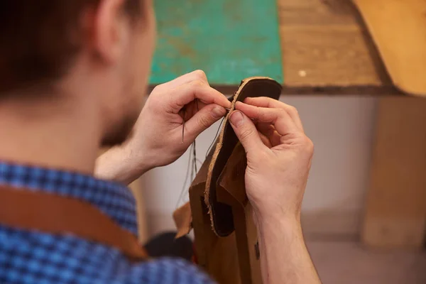 職人の手の閉鎖は メガネのための将来のケースのための針で茶色の革の部品を縫製 工房で針縫いの革を持った男 茶色の革 糸で働く職人 — ストック写真
