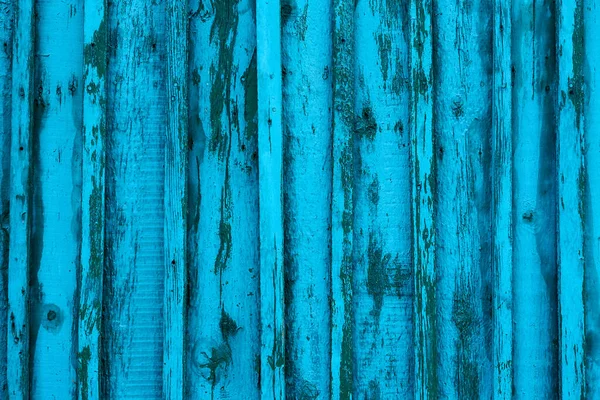 Texture of old wooden boards with peeling paint. Old weathered wooden plank painted in blue color.