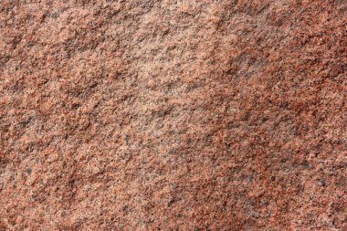 Desen ve arkaplan için yatay kahverengi-kırmızı taş dokusu. Taş kaba duvarın yakın çekimi..