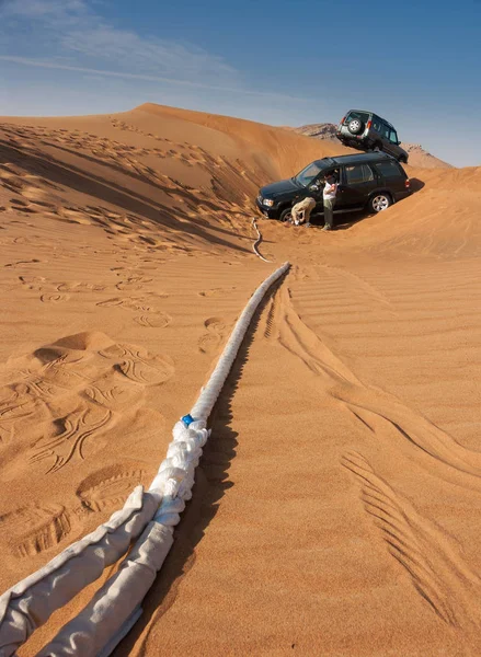 off-road one stuck in sand with attached rope