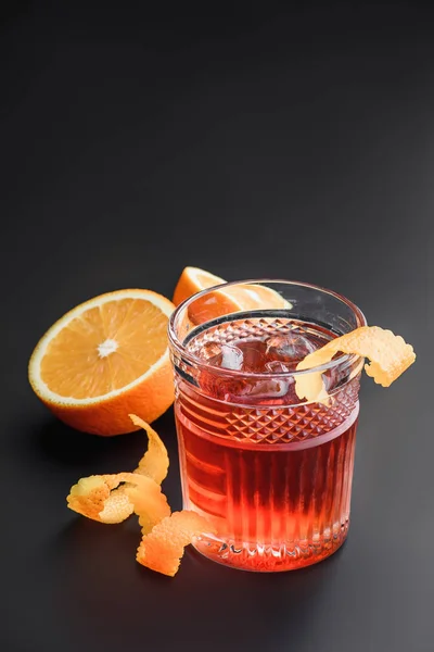 Κοκτέιλ με ουίσκι, ρούμι, και τα πορτοκάλια στο παρασκήνιο. Μαύρο φόντο. — Φωτογραφία Αρχείου
