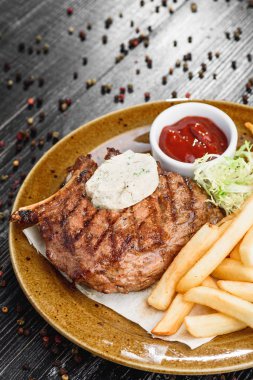 Orta nadir ızgara sığır eti biftek kahverengi plaka üzerinde ahşap siyah arka plan üzerine