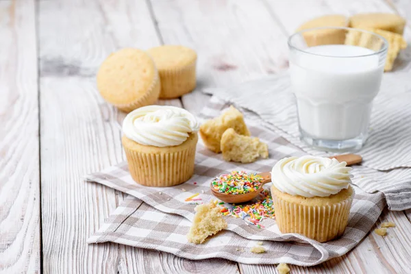 Sabrosos cupcakes sobre una mesa de madera blanca — Foto de Stock