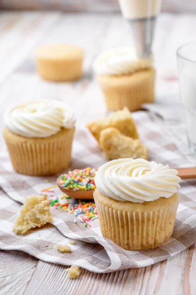 Leckere Cupcakes auf einem weißen Holztisch — Stockfoto