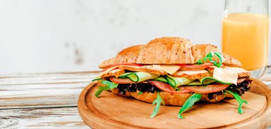 Kruvasan sandviç ile Türkiye, peynir ve salata roka suyu Beyaz ahşap tablo