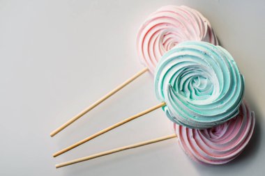 çubuk üzerinde pastel renklerde meringues