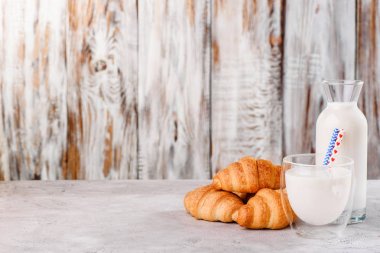 kruvasan ahşap arka plan üzerinde süt ile