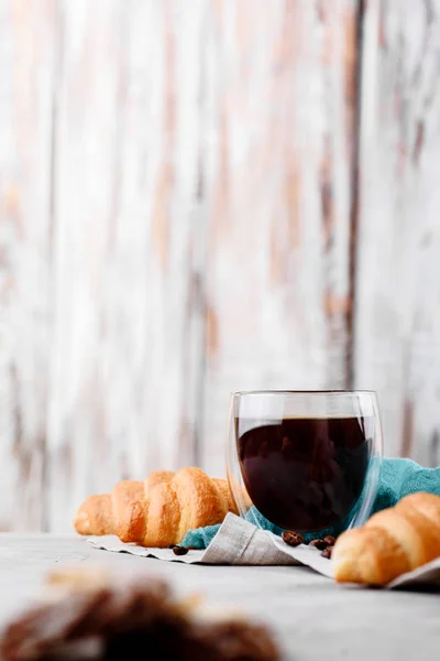 Croissants in houten platen met koffie op een lichte achtergrond — Stockfoto