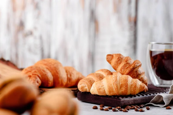 Croissants en platos de madera con café sobre un fondo claro — Foto de Stock