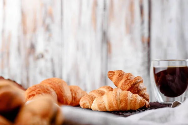 Croissants en platos de madera con café sobre un fondo claro — Foto de Stock