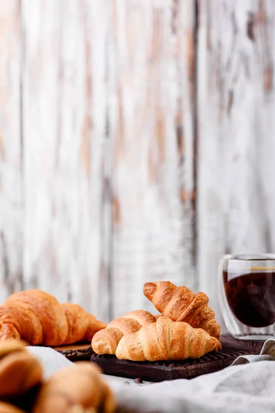 Croissants en platos de madera con café sobre un fondo claro — Foto de Stock