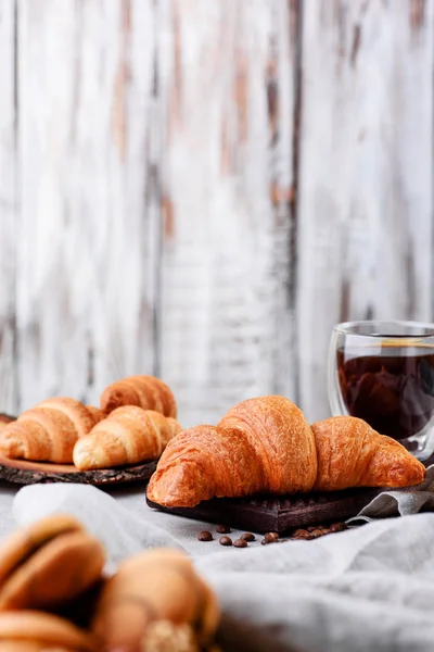 Croissants en platos de madera con café sobre un fondo claro — Foto de Stock