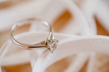 Bej renkli arka plan üzerinde bir elmas ile güzel bir gümüş yüzük.