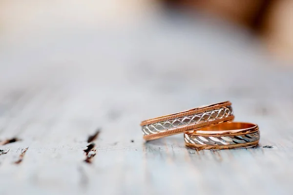Beautiful wedding rings on a light wooden background. — Stock Photo, Image