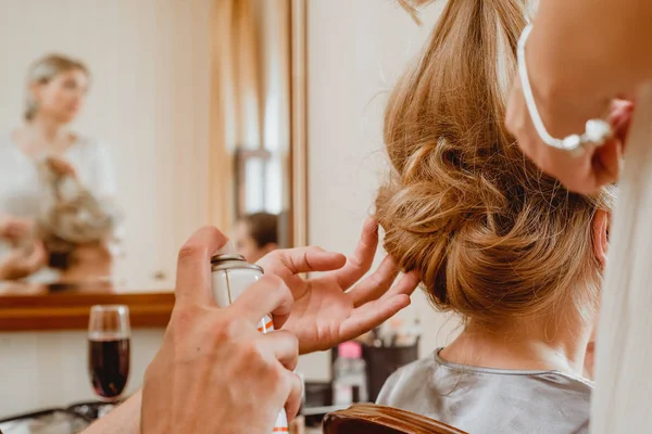 Master stylist makes the girl hairstyle using spray lacquer fixing — Stock Photo, Image