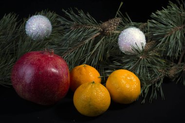 meyveler mandalina limon nar üzerinde koyu arkaplan ve Noel ağacı