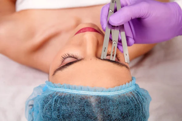 Kvinna att göra permanent makeup Stockbild