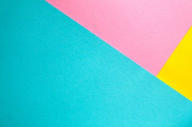 Renkli kağıtlar üst üste yığılmış. Pembe, mavi, sarı, kalın kağıt. Renkli parlak kağıt arkaplanı.