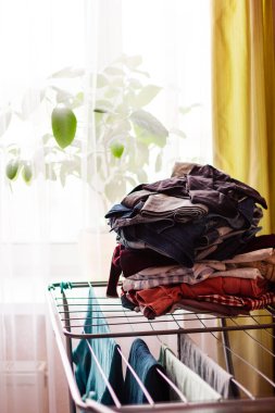 Pencerenin yanındaki dairede renkli giysiler için kuru askı.