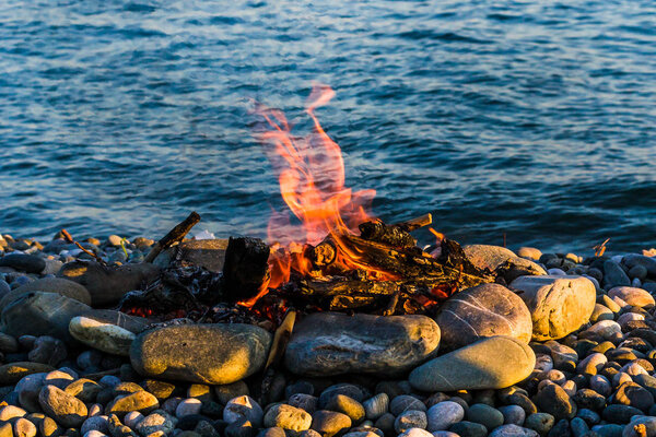 Костер на скалистом пляже
