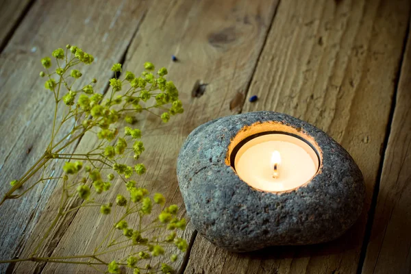 Świecznik z herbaty światła na tło w wieku drewna, wiosną delikatne żółte kwiaty, Wielkanoc, medytacja z kamienia — Zdjęcie stockowe