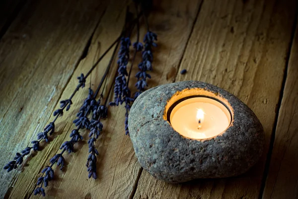 Kamenný svícen s čajové svíčky na stodole dřevo, levandule větvičky, Velikonoce, mír a klid konceptu — Stock fotografie