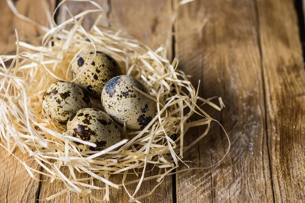Huevos de codorniz en un nido de paja en madera de granero, agricultura, Pascua, alimentos orgánicos saludables — Foto de Stock