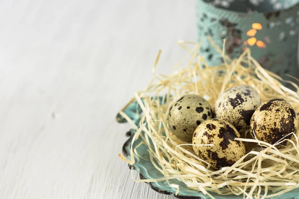 Bıldırcın yumurtası vintage tabakta, arka plan, Paskalya, retro tarzı içinde yanan mum saman bir yuvada — Stok fotoğraf