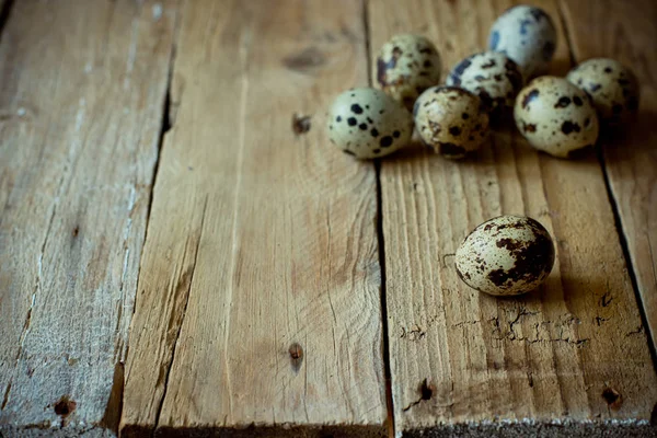 Huevos de codorniz dispersos sobre fondo de madera envejecida, estilo vintage rústico — Foto de Stock