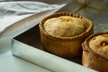 Ev yapımı pork pies alüminyum fırın tepsisindeki altın kabuk ile fırından yeni çıkmış, yakın çekim