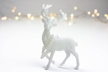 Arka planda bir Ren geyiği ve bokeh ışıklı İskandinav tarzı beyaz Christmas dekorasyon