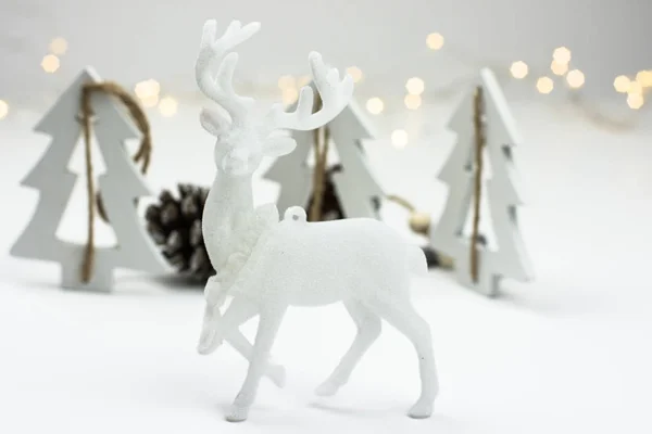 Белые рождественские украшения в скандинавском стиле с оленями, елками и сосновыми шишками — стоковое фото