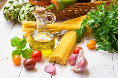 İtalyan ve Akdeniz mutfağı malzemeler, spagetti, zeytinyağı, sarımsak, domates, enginar, sepet mutfak masasında, sağlıklı beslenme biber