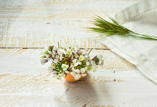 Białe kwiaty w skorupce, białe serwetki, Zielona trawa, ranek miękkie światło słoneczne, Wielkanoc ozdoby, na dzień matki — Zdjęcie stockowe