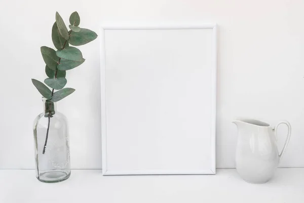 Mockup cornice bianca, ramo di eucalipto in bottiglia di vetro, brocca, immagine pulita minimalista in stile per il marketing del prodotto — Foto Stock
