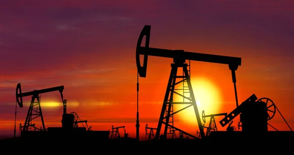 Нефтяные насосы - добыча нефти на фоне заката — стоковое фото
