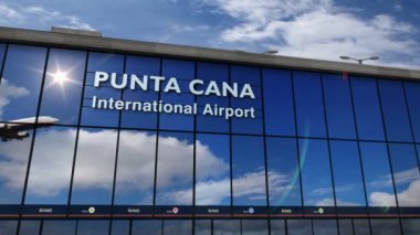 Punta Cana, Dominik Cumhuriyeti 'ne iniş yapan bir jet uçağı. Cam havaalanı terminali ve uçak yansıması olan şehre varış. Seyahat, iş, turizm ve ulaşım.