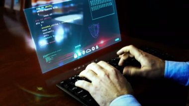 Masada sanal hologram ekranında program kodlu klavye yazan bir adam var. Programcı evde çalışıyor, bilgisayar programlama, kodlama ve siber teknoloji fütüristik kavram. El sıkışma kamerası.