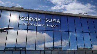 Bulgaristan 'ın başkenti Sofya' ya iniş yapan jet uçağı animasyonu canlandırıyor. Cam havaalanı terminali ve uçağın yansıması ile şehre varış. Seyahat, iş, turizm ve ulaşım kavramı.