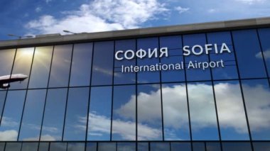 Bulgaristan 'ın başkenti Sofya' ya iniş yapan jet uçağı animasyonu canlandırıyor. Cam havaalanı terminali ve uçağın yansıması ile şehre varış. Seyahat, iş, turizm ve ulaşım kavramı.