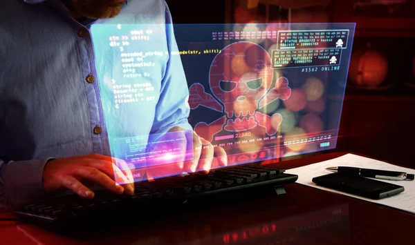 Hacker typing on the keyboard and breaks computer security on virtual hologram screen on desk. Cyber attack, cybercrime, piracy, digital safety and identity theft concept.