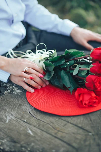 Gelin ve Damat Düğün yüzük ellerinde çiçekler yakınındaki