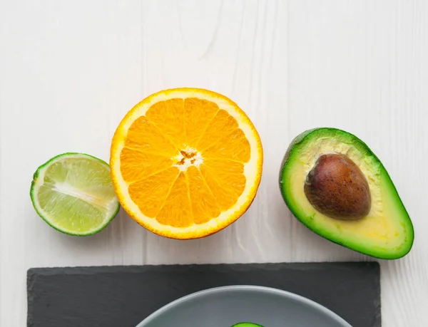 avokado, portakal ve limon taş tahta üzerinde