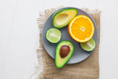 avokado, portakal ve limon ahşap arka plan üzerinde