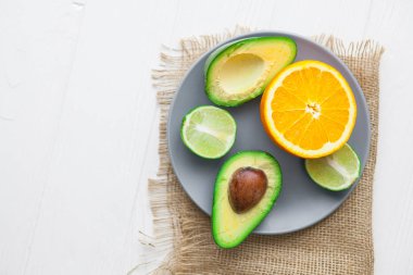 avokado, portakal ve limon ahşap arka plan üzerinde