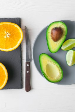 avokado, portakal ve limon taş tahta üzerinde